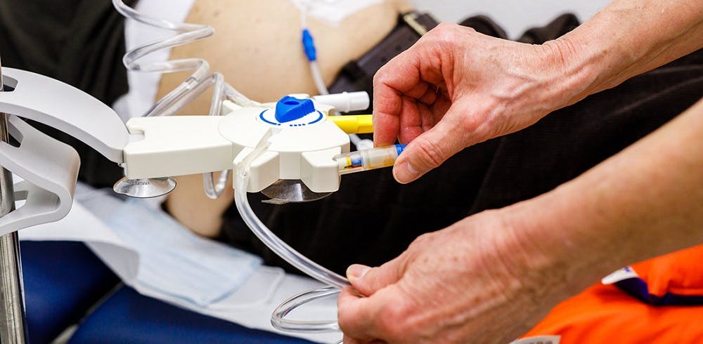 Medizinisches Personal bedient Dialysegerät beim Patienten.