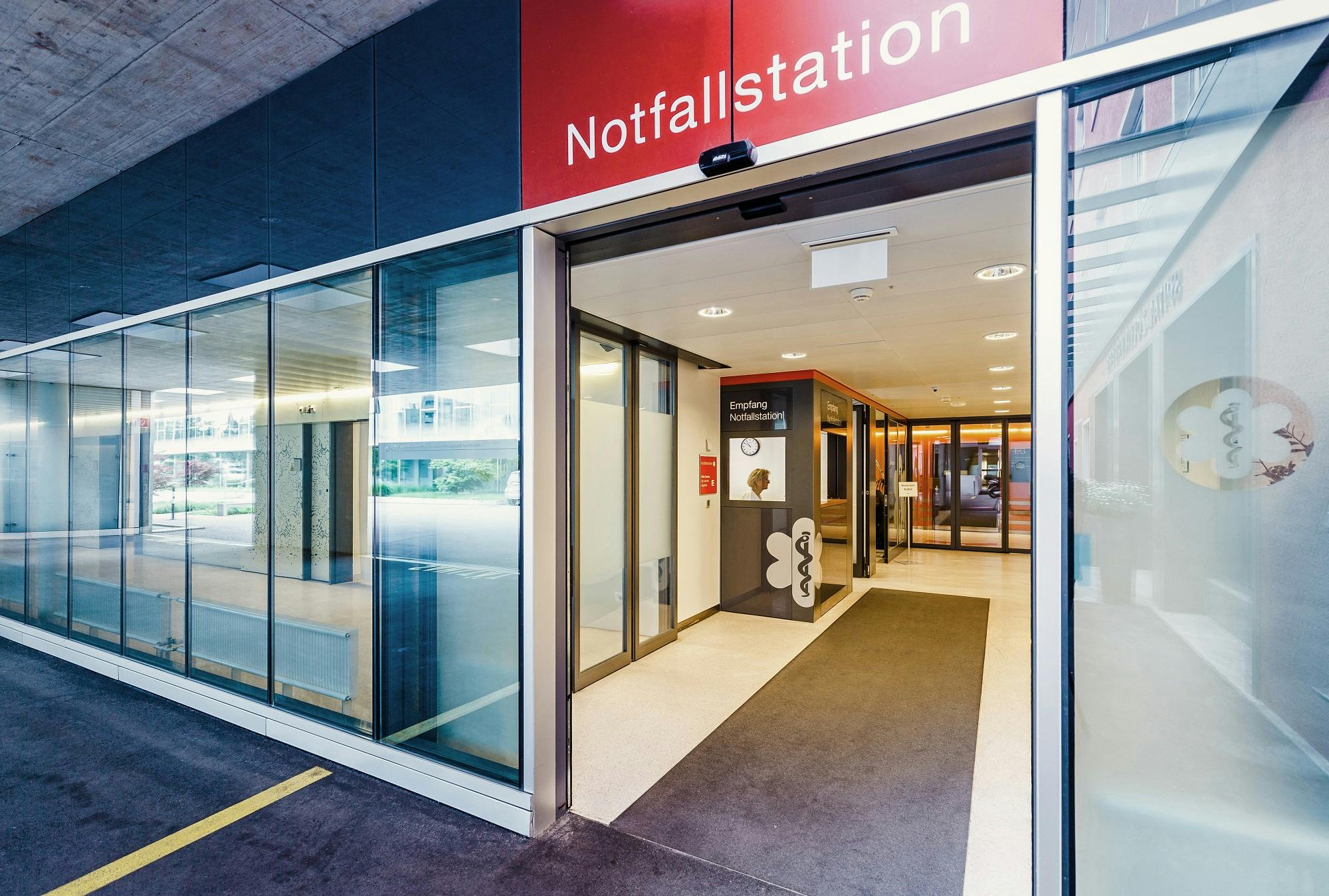 Eingang zur Notfallstation eines Krankenhauses mit automatischen Glastüren.